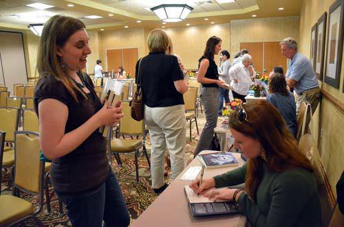 Author J. S. Chancellor signing books for a guest at the Rhemalda Publishing Got Stories Conference in Salt Lake City, Utah.