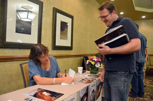 Author Cas Peace signing books for Mikey Brooks at the Got Stories Conference in Salt Lake City, Utah.
