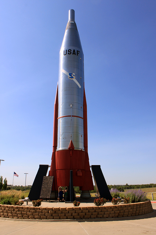 Rhett and the kids at the base of the rocket at the Strategic Air Command and Aerospace Museum.