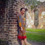 Emmaline Hoffmeister posing against a brick wall at the Old Sheldon Church.