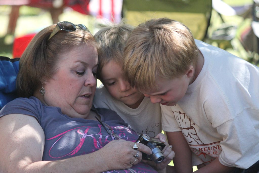 Grandma looking at pictures on her camera with ARH and DEH.