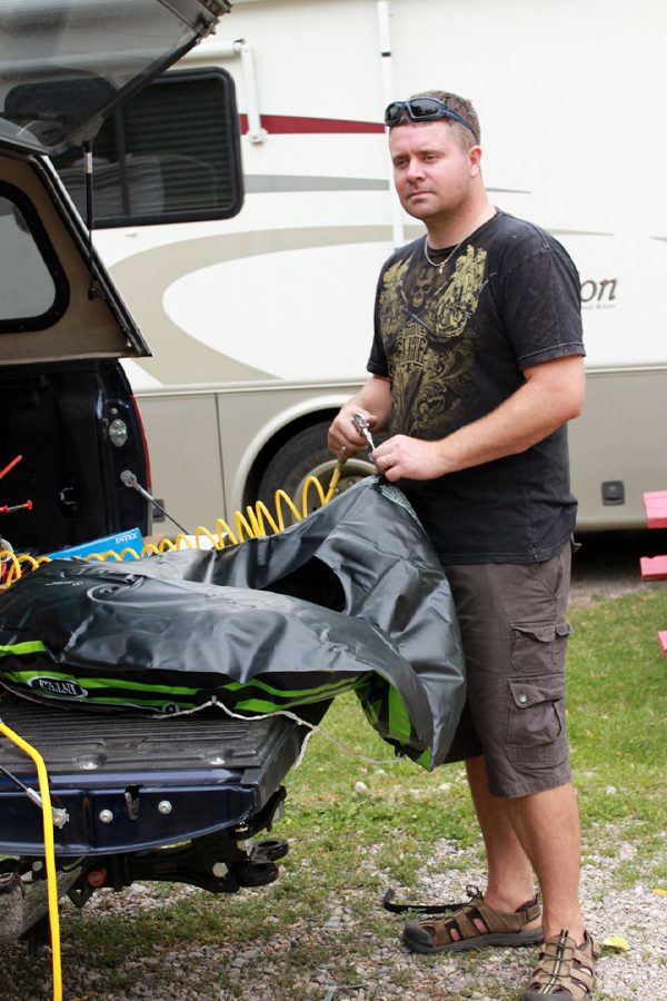 A man filling up a tube with an air compressor.