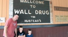 Rhett with ARH and DEH in front of the sign at Wall Drug in South Dakota.