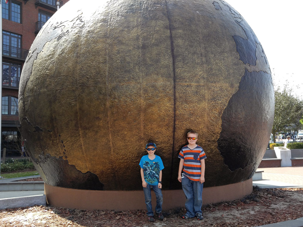 Two boys in front of the Savannah, Georgia world globe.