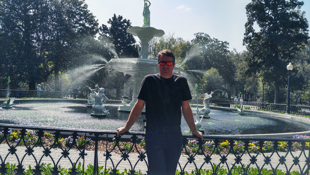 Man standing in front of a fountain at Forsyth Park in Savannah Georgia.